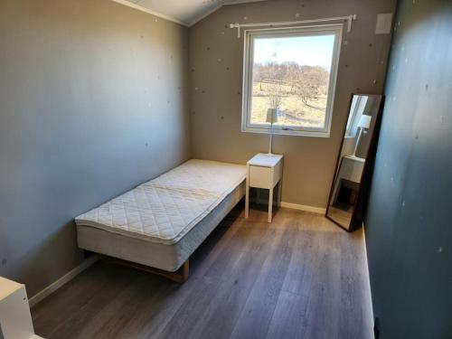 een kleine slaapkamer met een bed en een raam bij Igerøya in Mo