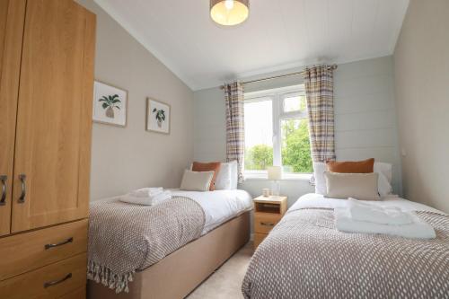 two beds in a small room with a window at 6 Faraway Fields in Liskeard