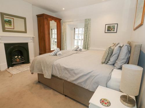 a bedroom with a large bed and a fireplace at Bobbin Cottage in Swanage