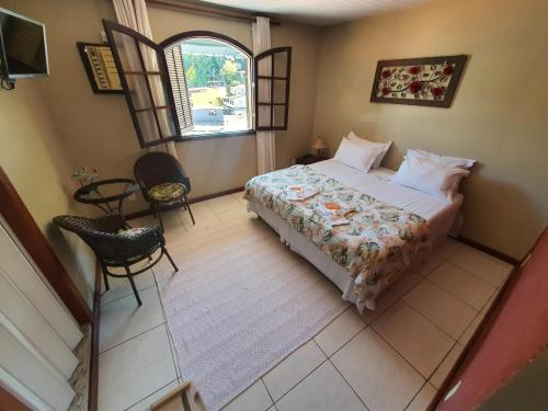 an aerial view of a bedroom with a bed and a window at Pousada Tuiuiu in Angra dos Reis