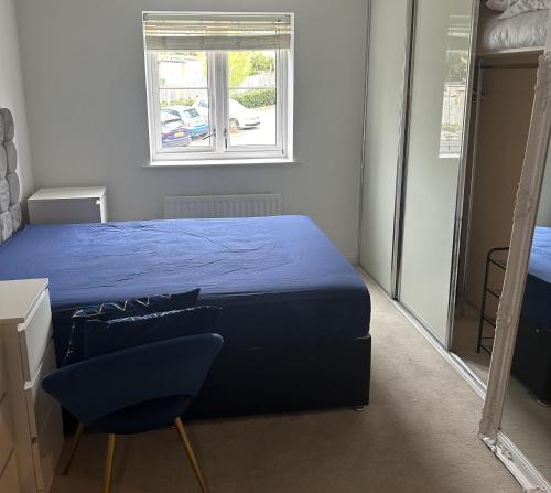 a bedroom with a blue bed and a window at Inviting 2-Bed Apartment in Bushey in Bushey