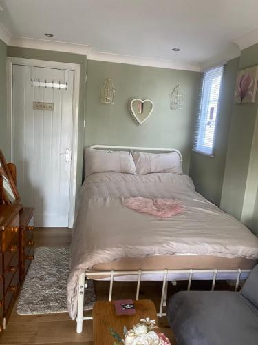 a bedroom with a bed with a heart on the wall at Private en-suite RUTHIN in Llanfair-Dyffryn-Clwyd