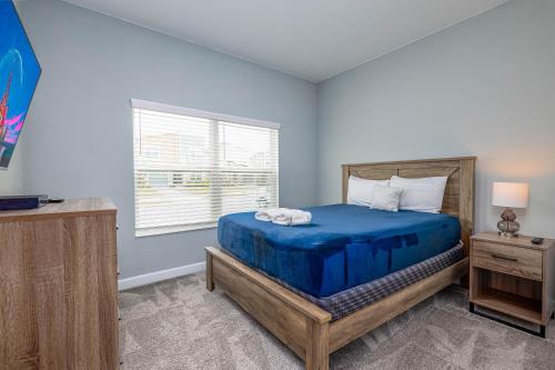 - une chambre avec un lit bleu et une fenêtre dans l'établissement TVPM-4263PD SL townhouse, à Kissimmee
