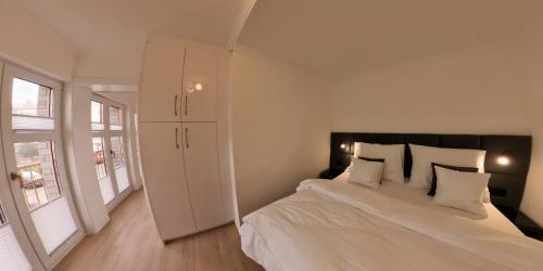 a bedroom with a large white bed with white pillows at Goldfin apartments in Ustka