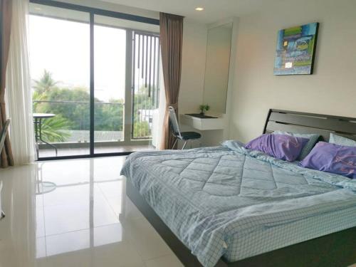 1 dormitorio con 1 cama grande y balcón en Entired 1 Bedroom Seaview Condo@Cape Panwa Beach, en Ban Ao Makham