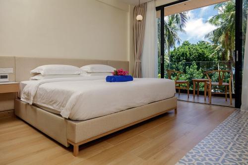 1 dormitorio con 1 cama grande y balcón en Kinan Boutique, en Fulidhoo