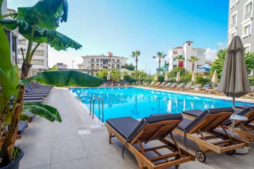 a swimming pool with lounge chairs and umbrellas at a hotel at Ada Julian Marmaris in Marmaris