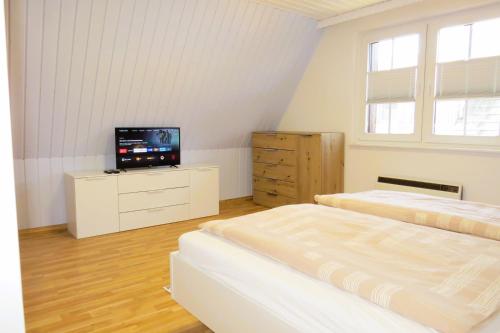 ein Schlafzimmer mit 2 Betten und einem TV auf einer Kommode in der Unterkunft Ferienhaus Prerow in Prerow