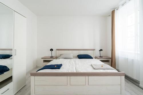 1 dormitorio con 1 cama blanca grande con almohadas azules en Apartment Schönbrunn Palace en Viena