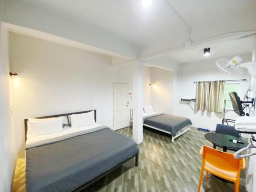 een ziekenhuiskamer met een bed, een bureau en een stoel bij The Alex in Ban Don Muang