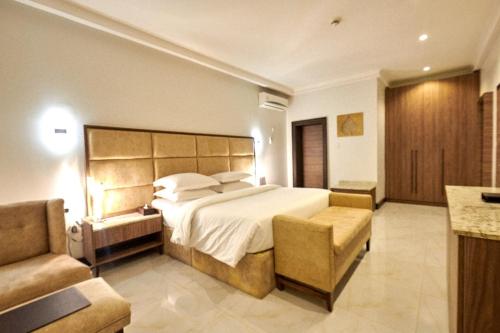 a large bedroom with a large bed and a couch at MEETHAQ HOTELS MAITAMA in Abuja