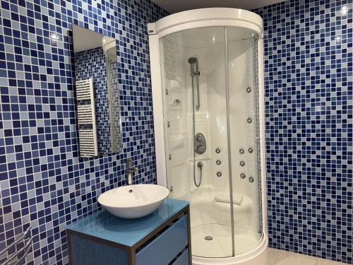 ヴィラモウラにあるMarina Vilamoura Aquamar 209 By Vilamoura Sunの青いタイル張りのバスルーム(シンク、シャワー付)
