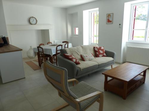 un salon avec un canapé et une table dans l'établissement Gite des Limagnes, à Thiviers