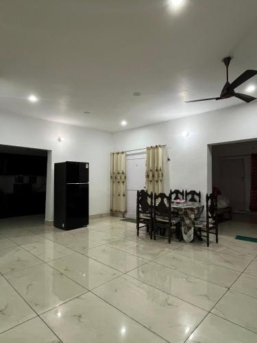 a living room with a table and chairs and a ceiling fan at A Place To Call Home in Jammu