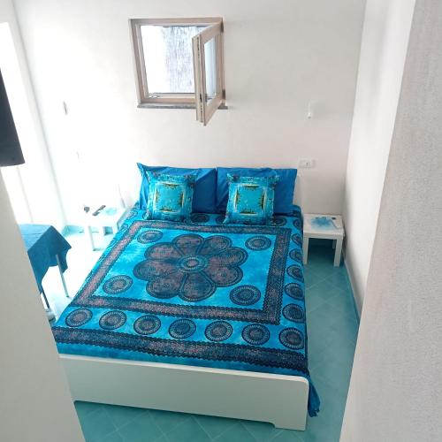a bedroom with a bed with blue pillows at Domus Julia in Furore