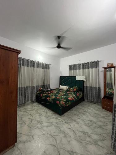 a bedroom with a bed and a ceiling fan at A Place To Call Home in Jammu