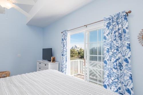 a blue bedroom with a bed and a window at New Listing - Shrimp On Da Fly! in St. Helena Island