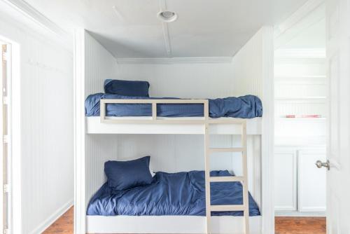 two bunk beds in a white room with blue pillows at New Listing - Shrimp On Da Fly! in St. Helena Island