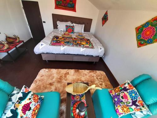 a small bedroom with a bed and a couch and a table at Suma uta lodge in Puno