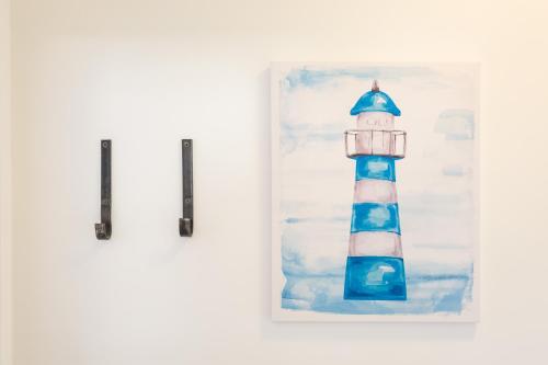 una pintura de un faro azul y blanco en STAR of the SEA, en Jesenice