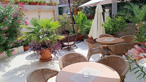 eine Terrasse mit Tischen und Stühlen sowie einem Sonnenschirm und Pflanzen in der Unterkunft Villa Rosi in Sozopol