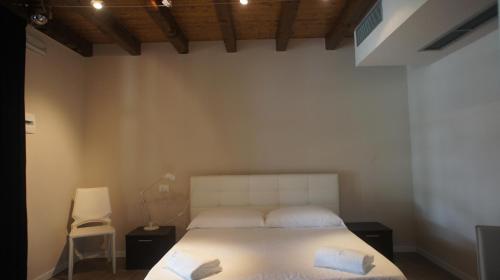 a bedroom with a white bed and a chair at Hotel Eremo in Soriano nel Cimino