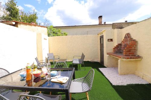 a patio with a table and chairs and a fireplace at Le Patio - Spacieux et lumineux T3 - 15 min centre pieds in Bergerac