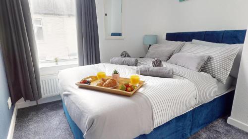 a tray of food on a bed with fruit on it at Modernised 3-bedroom Blackburn townhouse sleeps 6 in Rishton