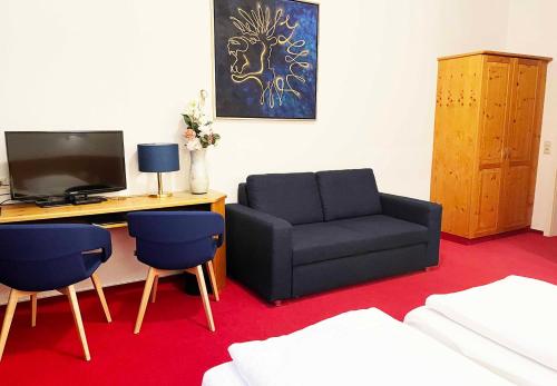 - un salon avec un canapé et une chaise dans l'établissement Hotel Restaurant Krokodil, à Heidelberg