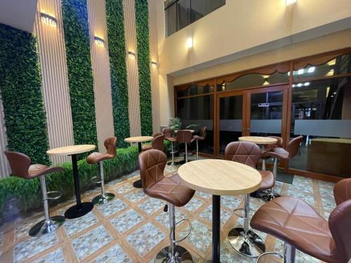 a lobby with tables and chairs and a green wall at Gran Kunturwasi Hotel Corporativo in Cajamarca