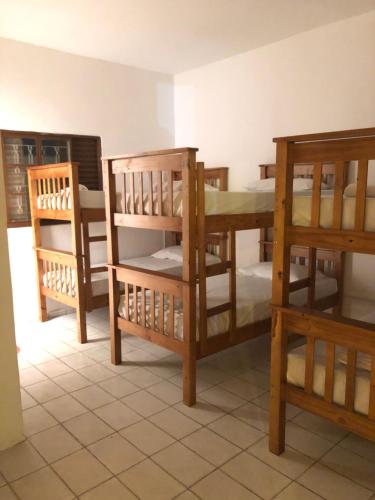 um quarto com vários beliches num quarto em Rosa dos Ventos Hostel em Boiçucanga