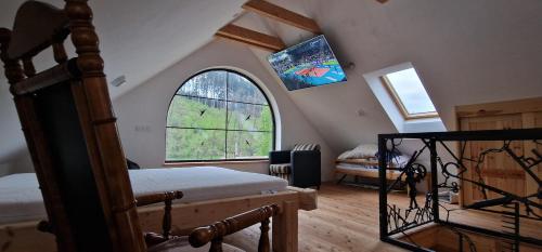 a bedroom with a bed and a large window at Chalupa Trucovna 