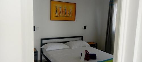 a bedroom with a bed and a picture on the wall at Résidence ÉBÈNE - Villas in Antsakomboena