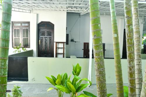 a room with palm trees and a door at Coconut Villa in Arugam Bay