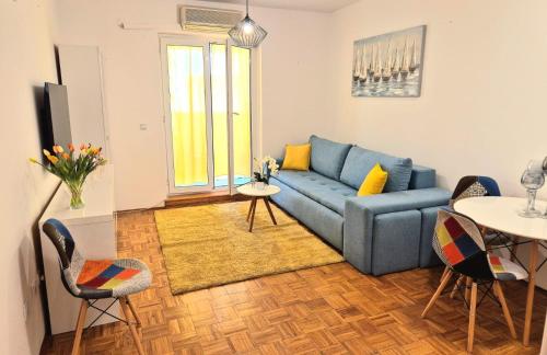 a living room with a blue couch and a table at Apartman Lopar Selce in Selce
