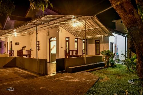 a house with a lit up porch at night at Coconut Villa in Arugam Bay