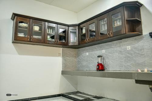 a kitchen with wooden cabinets and a red blender on a counter at Coconut Villa in Arugam Bay