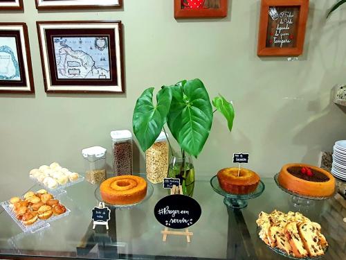 a table topped with different types of cakes and pastries at Pousada Tuiuiu in Angra dos Reis