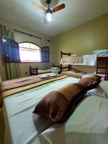a bedroom with two beds and a ceiling fan at Pousada Tuiuiu in Angra dos Reis