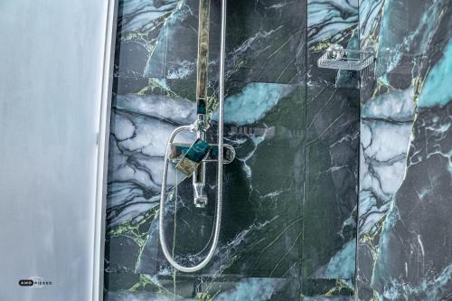 a shower in a bathroom with a stone wall at Coconut Villa in Arugam Bay