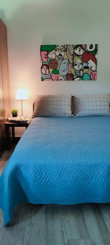 um quarto com uma cama azul com um quadro na parede em Cosy Garden Studio em Messini