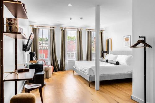 a bedroom with a bed and a desk and windows at West Market Square View, Historic Hotel DTWN, King Bed, Room # 401 in Bangor