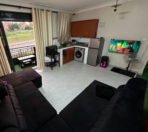 a living room with a couch and a kitchen at Durlan metroplex in Kampala