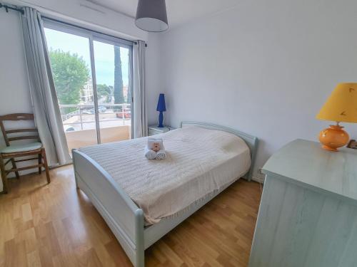 une chambre avec un lit avec deux ours en peluche dessus dans l'établissement Les Tournesols, à Hyères