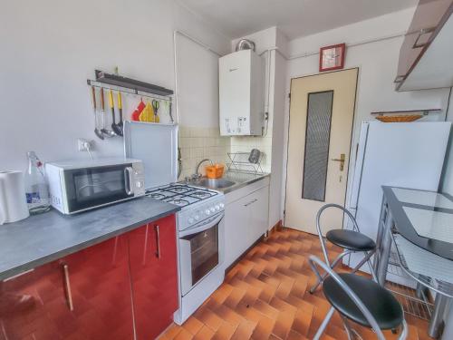 une cuisine avec une cuisinière et un micro-ondes dans l'établissement Les Tournesols, à Hyères