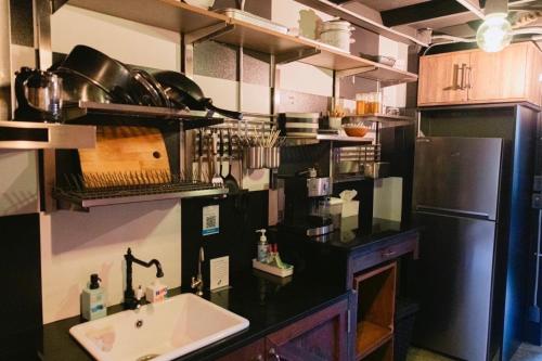 a kitchen with a sink and a black counter top at New York Loft & Japanese Magic by V4SKIN in Bangkok