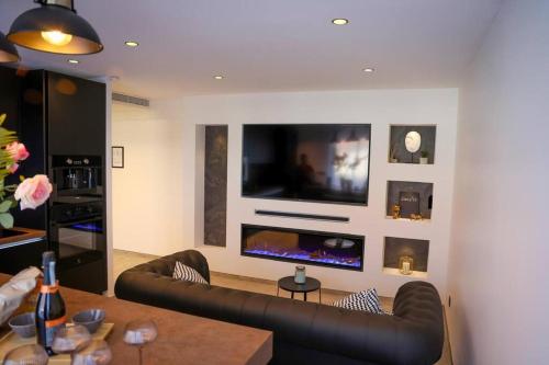 un salon avec un canapé et une télévision à écran plat dans l'établissement Blancs de blancs, à Cannes