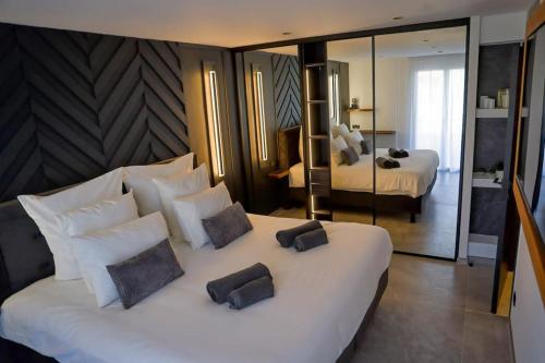 - une chambre avec un grand lit blanc et des miroirs dans l'établissement Blancs de blancs, à Cannes