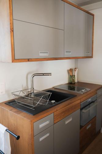 a kitchen counter with a sink and a dish rack at Seesicht und charmante Wohnung bei Hanni und Ueli in Bottighofen