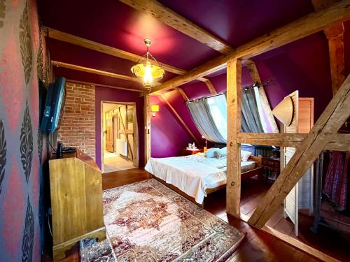 um quarto com paredes roxas e uma cama num quarto em Dom na wsi okolice Kołobrzegu em Charzyno